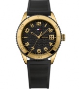 Bring drama to the game with this bold and durable watch by Tommy Hilfiger. Ribbed black silicone strap and round gold ion-plated stainless steel case. Gold tone and black bezel etched with numerals. Logo-embossed black dial features applied gold tone numerals, minute track, three hands and flag logo. Quartz movement. Water resistant to 30 meters. Ten-year limited warranty.