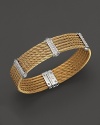 From the Classique collection by Charriol, an elegant stainless steel and yellow PVD cable bangle with diamond stations in 18K white gold.