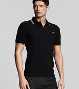 Widely known as the pioneer of Mod, British street fashion, Fred Perry polos have become an iconic fashion silhouette. A sporty polo with contrast double stripe trim and embroidered logo at left chest. Slim fit.