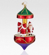 Miniature Santa figurines are set atop this glittery Christmas carousel. Hand-blownHand-painted6½ highMade in Poland