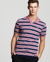 Dusty pink and navy stripes cover this slim fit short sleeve polo from Lacoste.