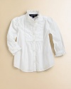 A traditional button-front design in timeless cotton poplin features pintucked detailing and ruffle trim for a girly look.Ruffled stand collarLong sleeves with single-button barrel cuffsButton-frontShirttail hemCottonMachine washImported Please note: Number of buttons may vary depending on size ordered. 
