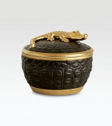 A candle with the intoxicating scent of pink champagne is encased in this vessel with the texture of crocodile skin, handcrafted of fine black Limoges porcelain with 14k goldplated accents. Includes fitted lid with a clasp sculpted in the shape of an crocodile. Handcrafted porcelain 6H X 4 diam. Imported 