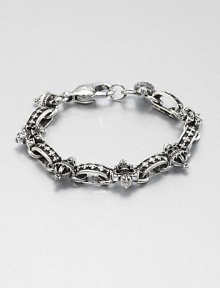 A remarkably detailed fleur de lis of sterling silver and skull charm accents a simple, sophisticated sterling silver bracelet.Sterling silverWidth, about 8mmDiameter, about 3Lobster claspMade in USA A remarkably detailed fleur de lis of sterling silver and skull charm accents a simple, sophisticated sterling silver bracelet.Sterling silverWidth, about 8mmDiameter, about 3Lobster claspMade in USA