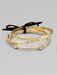 A set of three subtly textured golden bangles, each a little different, with undulating edges and shimmering rhinestones.GlassBrassDiameter, about 2½Imported