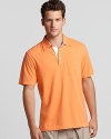 A vivid orange polo from Michael Kors with a contrast three button placket--a comfy weekend essential.