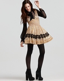A metallic foil print adds glamour to this Free People dress, featuring a seductive, plunging neckline and purple sheer lace trim. A metallic foil print adds glamour to this Free People dress, featuring a seductive, plunging neckline and purple sheer lace trim.