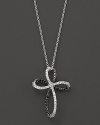 Black and white diamonds, set in 14K. white gold, form an elegant cross.