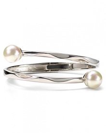 An understated offering from Majorica, this bangle features overlapping contoured sterling silver bands with man-made pearl accents. An understated offering from Majorica, this bangle features overlapping contoured sterling silver bands with man-made pearl accents.