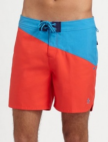 An easy-fitting swim favorite with a colorblocked design of saturated color in quick-dry nylon. Drawstring waist Side slash, back flap pockets Mesh lining Inseam, about 6 Polyester Machine wash Imported 