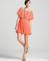 Vibrant coral colors this flirty BCBGMAXAZRIA dress with a ruffle at top and layered pleats at the skirt. The picture of party perfection, the silhouette pops amongst a sea of LBDs.