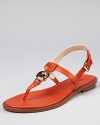 Burnt orange leather feels luxe, glammed up by a gleaming gold-tone logo disc and buckle closure. From MICHAEL Michael Kors.