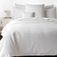 Clean, crisp and classic white, this elegant Barbara Barry decorative pillow boasts rows of fine pintuck pleats for a tailored statement of modern comfort. Clean, crisp and classic white, this elegant Barbara Barry decorative pillow boasts rows of fine pintuck pleats for a tailored statement of modern comfort.
