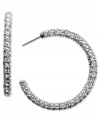 Sparkly crystals add a glamorous edge to classic hoop earrings. Silvertone posts. Diameter measures 1-3/8 at widest point.