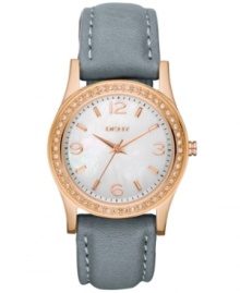 A new everyday watch fit for the on-the-move professional, by DKNY. Watch crafted of dark gray leather strap with white stitching and oval rose-gold ion-plated stainless steel case. Bezel embellished with 38 clear crystal accents. White dial features rose-gold tone three hands, numerals at three, six, nine and twelve o'clock, minute track and logo at twelve o'clock. Quartz movement. Water resistant to 50 meters. Two-year warranty. A new everyday watch fit for the on-the-move professional, by DKNY. Watch crafted of dark gray leather strap with white stitching and oval rose-gold ion-plated stainless steel case. Bezel embellished with 38 clear crystal accents. White dial features rose-gold tone three hands, numerals at three, six, nine and twelve o'clock, minute track and logo at twelve o'clock. Quartz movement. Water resistant to 50 meters. Two-year warranty.