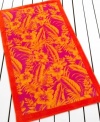 A bold pattern of tropical flowers is framed by a solid border in this beach towel from Lauren by Ralph Lauren, featuring a sizzling palette of orange, yellow and pink.