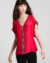 The lady in red gets a modern makeover with this Parker top. The cutout shoulder details and ornate beading are a sweet style twist. Pair it with your favorite skinny jeans and heels.