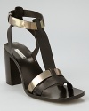 Metallic accents jazz up sleek black leather, while a chunky block heel feels right on trend. From Calvin Klein.