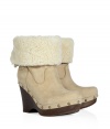 Show off your impeccable style while maintaining warmth and comfort in these wedge clogs with a cozy shearling cuff from UGG Australia - Round toe, platform, wooden wedge heel, stud-detailed trim, shearling cuff, adjustable back with D-ring buckle, ankle length - Pair with skinny jeans, an oversized cashmere sweater, and a down jacket or wool cape