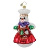 A smiling chef snowman holds a Christmas garland of holiday goodies-a snowflake, tree and snowman.