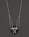 A bold sterling silver cage, glistening with diamonds, encases a gleaming black onyx stone. By Di MODOLO.