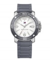 Keep your cool with this ultra-stylish and monochromatic sport watch by Tommy Hilfiger. Gray silicone strap and round silver tone mixed metal case with gray bezel. White dial features applied silver tone numerals at twelve, three, six and nine o'clock, stick indices, date window at three o'clock, three hands and logo. Quartz movement. Water resistant to 30 meters. Ten-year limited warranty.