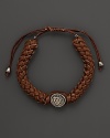 Silver Gucci charm on a braided brown natural leather bracelet.