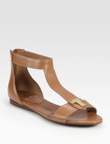 Lustrous leather t-strap with an exposed back zipper and a goldtone T embellishment. Leather upperBack zipperLeather liningRubber solePadded insoleImported