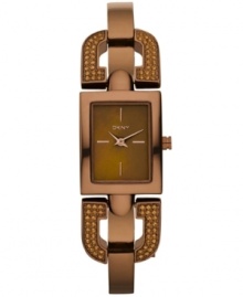 DKNY takes a unique turn with this darling sparkling bangle watch. Crafted of brown ion-plated stainless steel half-bangle bracelet with crystal-accented D-shaped links at rectangular case. Brown dial features rose-gold tone stick indices at three, six, nine and twelve o'clock, two hands and logo at twelve o'clock. Quartz movement. Water resistant to 50 meters. Two-year limited warranty.