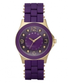 A passion for purple and fashion, by Marc by Marc Jacobs. Watch features purple silicone-wrapped stainless steel bracelet with gold ion-plated accents. Round gold ion-plated case with concave ring. Purple dial features logo, goldtone hands, numerals at twelve, three, six and nine o'clock and gold ion-plated dot markers. Quartz movement. Water resistant to 30 meters. Two-year limited warranty. A passion for purple and fashion, by Marc by Marc Jacobs. Watch features purple silicone-wrapped stainless steel bracelet with gold ion-plated accents. Round gold ion-plated case with concave ring. Purple dial features logo, goldtone hands, numerals at twelve, three, six and nine o'clock and gold ion-plated dot markers. Quartz movement. Water resistant to 30 meters. Two-year limited warranty.