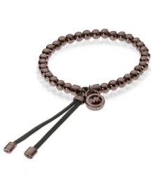 Slip-on stackable style! Michael Kors' chic stretch bracelet brings espresso tone beads and logo accents. Finished with espresso-tone mixed metal tipped, adjustable leather clasp. Approximate diameter: 2-1/4 inches. Slip-on stackable style! Michael Kors' chic stretch bracelet brings espresso tone beads and logo accents. Finished with espresso-tone mixed metal tipped, adjustable leather clasp. Approximate diameter: 2-1/4 inches.