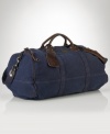 Ideal for travel, a rugged canvas duffle gets a luxe update from rich leather handles.