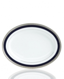 Formal white fine china displays a dramatic combination of scrolling leaves on shimmering platinum and an inner band of intense cobalt blue. Dishwasher safe. Formal white fine china displays a dramatic combination of scrolling leaves on shimmering platinum and an inner band of intense cobalt blue. Dishwasher safe.