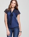 Gain instant style credo in this DKNYC blouse touting a monochrome palette and sheer detailing for modern femininity.