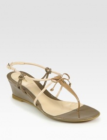 Italian patent leather in a multi-tone thong design with a sculpted wedge, dainty bow and goldtone designer emblem. Self-covered wedge, 2 (50mm)Patent leather upperLeather liningRubber solePadded insoleMade in ItalyOUR FIT MODEL RECOMMENDS ordering one half size down as this style runs large. Italian patent leather in a multi-tone thong design with a sculpted wedge, dainty bow and goldtone designer emblem. Self-covered wedge, 2 (50mm)Patent leather upperLeather liningRubber solePadded insoleMade in ItalyOUR FIT MODEL RECOMMENDS ordering one half size down as this style runs large.