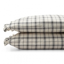 Dramatic black-and-cream checked sheets and pillowcases are edged in feminine pleated ruffles. Dramatic black-and-cream checked sheets and pillowcases are edged in feminine pleated ruffles.