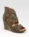 Suede with a substantial wedge, back zipper and criss-cross straps. Self-covered wedge, 3 (75mm)Covered platform, ½ (15mm)Compares to a 2½ heel (65mm)Suede upperBack zipperLeather liningRubber solePadded insoleImportedOUR FIT MODEL RECOMMENDS ordering one half size up as this style runs small. 