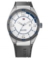 Smoky hues come to life with blue bursts of color on this casual Tommy Hilfiger watch. Crafted of gray silicone strap and round stainless steel case with logo. Gray bezel features blue numerals and stick markers. White dial features silver tone numerals at three, six, nine and twelve o'clock, stick markers, blue inner minute track, silver tone hour and minute hands, blue second hand, date window at three o'clock and iconic flag logo at twelve o'clock. Quartz movement. Water resistant to 50 meters. Ten-year limited warranty.