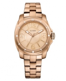 Classically styled timepiece with popping rosy hues, by Tommy Hilfiger. Crafted of rose-gold tone stainless steel bracelet and round case. Rose-gold tone dial features Arabic numerals at three, six, nine and twelve o'clock, stick indices, three hands and logo at twelve o'clock. Quartz movement. Water resistant to 30 meters. Ten-year limited warranty.