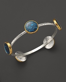 A bold sterling silver bangle from Gurhan with Paua shell stations in 24K yellow gold. A bold sterling silver bangle from Gurhan with Paua shell stations in 24K yellow gold.