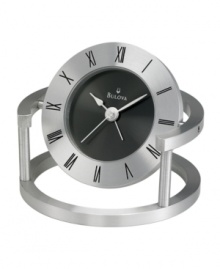 Contemporary flair marks this bedside alarm clock by Bulova. Spun and brushed aluminum frame holds a round pivoting case. Bezel etched with black Roman numerals and black dial features two silver tone hands. Features beep alarm. Contemporary flair marks this bedside alarm clock by Bulova. Spun and brushed aluminum frame holds a round pivoting case. Bezel etched with black Roman numerals and black dial features two silver tone hands. Features beep alarm.