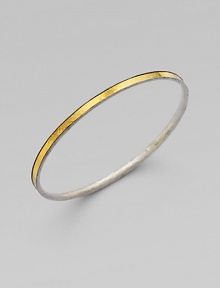 From the Lancelot Collection. Thoroughly modern and thoroughly stunning, this slender bangle of hammered sterling silver is encircled by a gleaming band of 24k gold.Sterling silver and 24k yellow goldDiameter, about 2½Imported