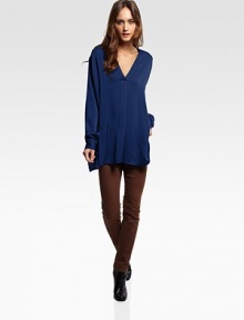 Oversized silk v-neck with a casual-cool hi-low hem and buttoned cuffs. V-neckLong sleevesButtoned cuffsSplit hi-low hem95% silk/5% spandexDry cleanImported Oversized silk v-neck with a casual-cool hi-low hem and buttoned cuffs. V-neckLong sleevesButtoned cuffsSplit hi-low hem95% silk/5% spandexDry cleanImported