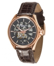 Stunning style and intricate design prevail in this Kenneth Cole New York watch. Brown croc-embossed leather strap and round goldtone stainless steel goldtone ion-plated case. Black dial with transparent windows, logo & luminous stick indices. Automatic movement. Water resistant to 30 meters. Limited lifetime warranty. Stunning style and intricate design prevail in this Kenneth Cole New York watch. Brown croc-embossed leather strap and round goldtone stainless steel goldtone ion-plated case. Black dial with transparent windows, logo & luminous stick indices. Automatic movement. Water resistant to 30 meters. Limited lifetime warranty.