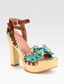 A dimensional bow tops this clog-inspired design with a powerful wooden heel and platform. Wooden heel, 5¼ (130mm)Wooden platform, 1¾ (45mm)Compares to a 3½ heel (90mm)Nylon and leather upper with metal studsAdjustable ankle strapLeather liningRubber solePadded insoleMade in Italy A dimensional bow tops this clog-inspired design with a powerful wooden heel and platform. Wooden heel, 5¼ (130mm)Wooden platform, 1¾ (45mm)Compares to a 3½ heel (90mm)Nylon and leather upper with metal studsAdjustable ankle strapLeather liningRubber solePadded insoleMade in Italy