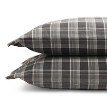 Inspired by the refined polish of menswear, this relaxed collection pairs solid brushed cotton and twill with faux suede trim and plaid. Sheets and pillowcases are in a soft cotton bold plaid in a grey and white palette. Inspired by the refined polish of menswear, this relaxed collection pairs solid brushed cotton and twill with faux suede trim and plaid. Sheets and pillowcases are in a soft cotton bold plaid in a grey and white palette.