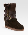 Shearling-lined essential of buttery suede with a hidden wedge and leather buckled straps. Suede-covered wedge, 3¼ (80mm)Rubber platform, ¾ (20mm)Compares to a 2½ heel (65mm)Shaft, 7Leg circumference, 10Suede upper with leather adjustable buckle strapsShearling liningRubber trek solePadded insoleImportedOUR FIT MODEL RECOMMENDS ordering one half size up as this style runs small. 