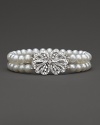 Double stranded bracelet of cultured, freshwater pearls accented with a diamond bow clasp.