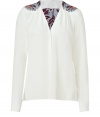 The classic white shirt gets a boho-inspired redux with this printed version from Schumacher - V-neck, gathered shoulders with printed detail, front button placket, long sleeves, asymmetric hem with vents, relaxed fit - Wear with flared jeans and platform heels