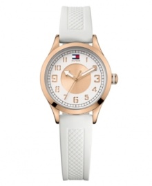 Punctuality gets pretty with this glammed up sport watch by Tommy Hilfiger. White textured silicone strap and round rose-gold-plated stainless steel case. Double-layered white and rose-gold tone dial features cut-out numerals, black minute track, flag logo at twelve o'clock and three hands with rose-gold tone accents. Quartz movement. Water resistant to 30 meters. Ten-year limited warranty. Punctuality gets pretty with this glammed up sport watch by Tommy Hilfiger. White textured silicone strap and round rose-gold-plated stainless steel case. Double-layered white and rose-gold tone dial features cut-out numerals, black minute track, flag logo at twelve o'clock and three hands with rose-gold tone accents. Quartz movement. Water resistant to 30 meters. Ten-year limited warranty.